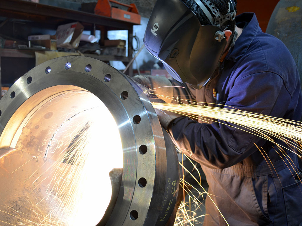 Welder cutting heavy pipe